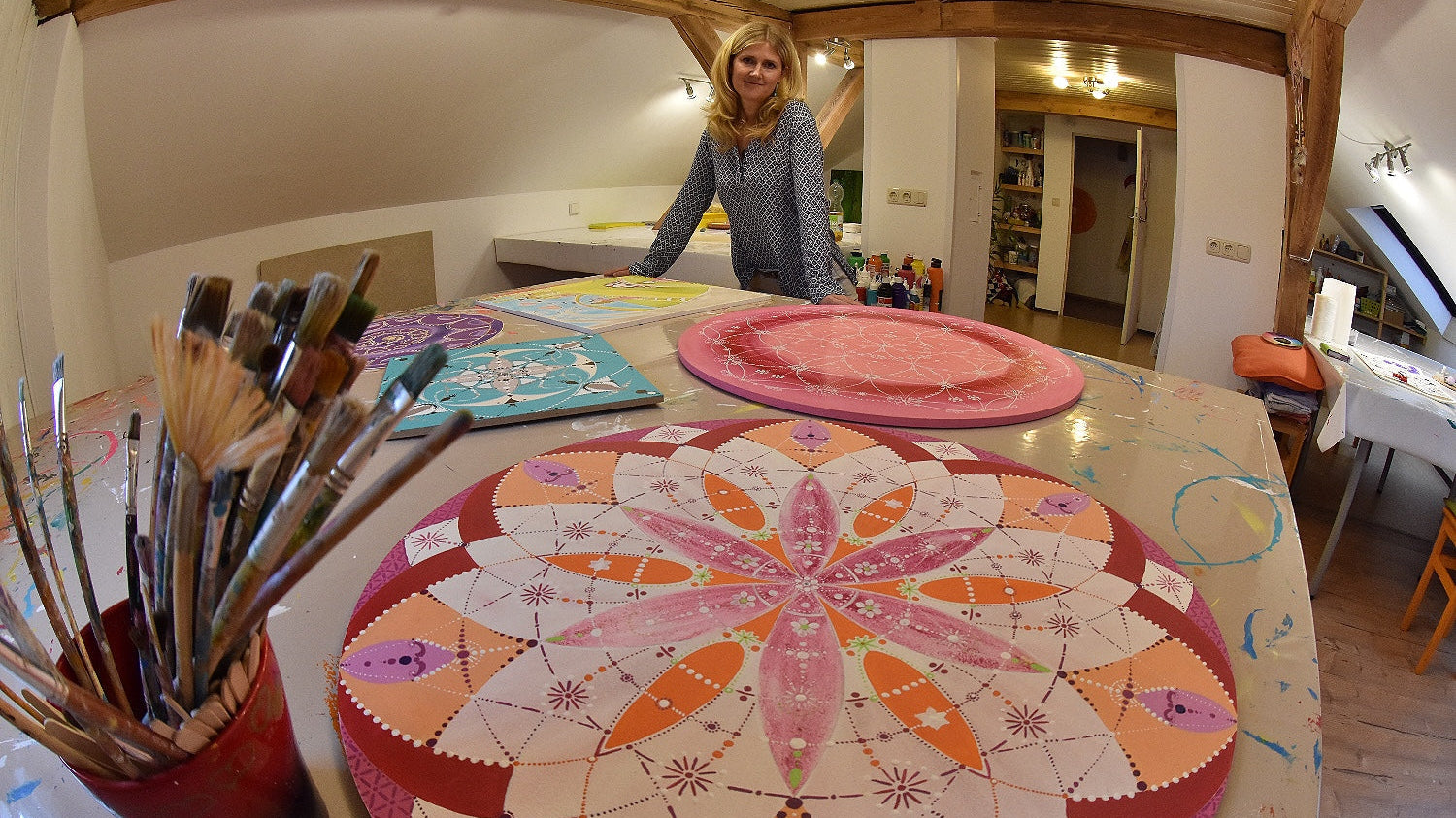 Blick in die gemütliche PINSELTANTE® Kreativwerkstatt in Oberasbach bei Nürnberg mit einem großen, bunten Maltisch für Gruppen-Workshops.