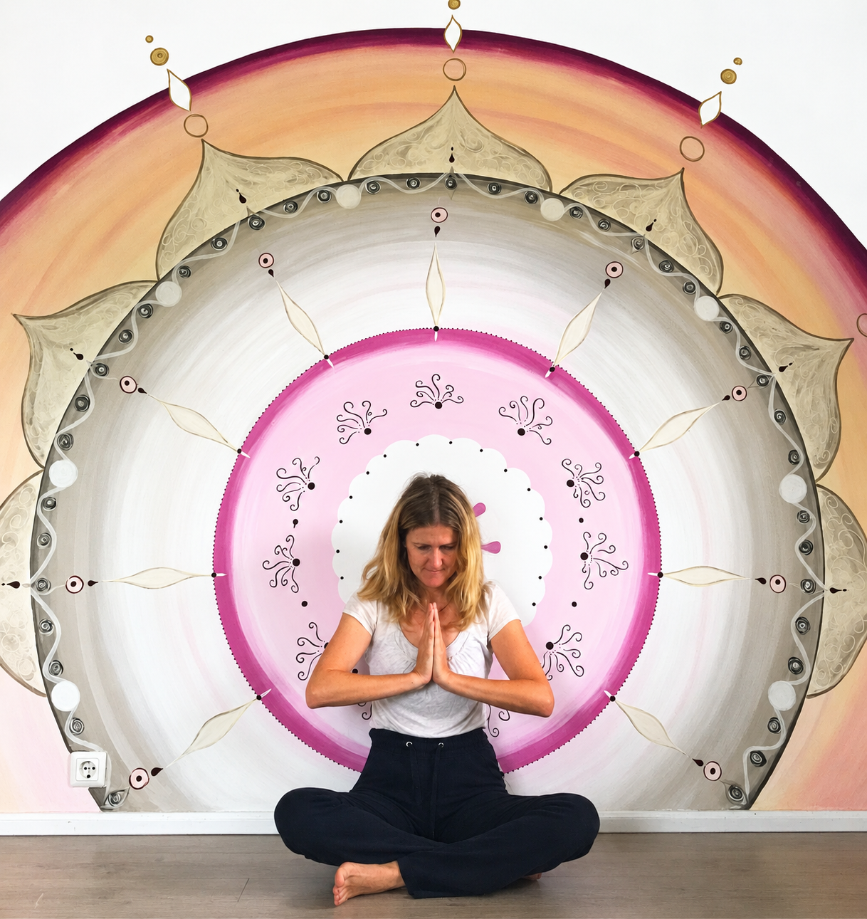 Doreen Gündel vor großem selbstgemaltem Mandala auf der Wand 
